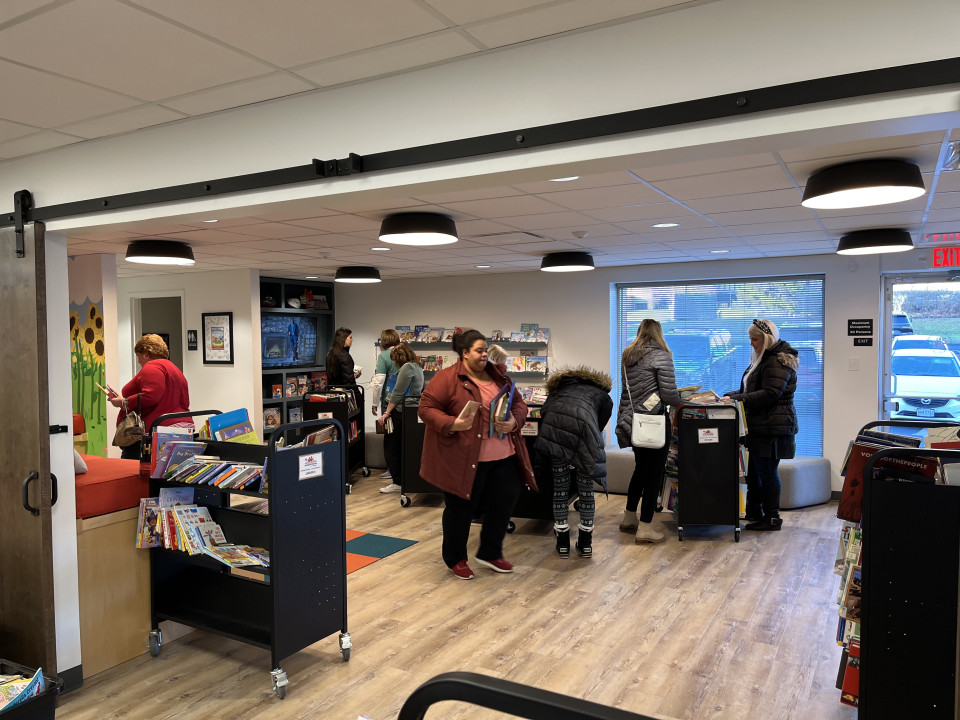 People gathering for a book giveaway event at 2nd & 7's office